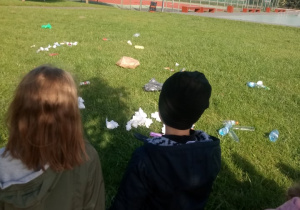 dzieci obserwują zaśmiecony park
